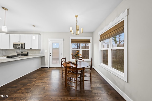 dining room featuring baseboards, a chandelier, and dark wood finished floors