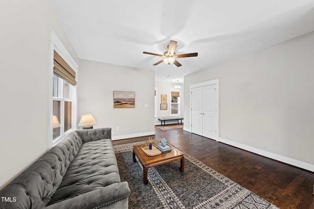 living room with dark wood-type flooring, baseboards, and a ceiling fan