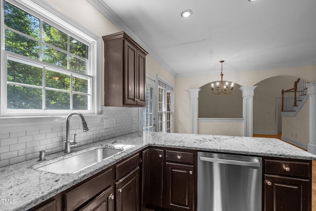 kitchen with dark brown cabinetry, a sink, dishwasher, tasteful backsplash, and ornate columns