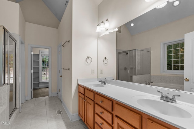 bathroom featuring double vanity, a shower stall, a sink, and tile patterned floors