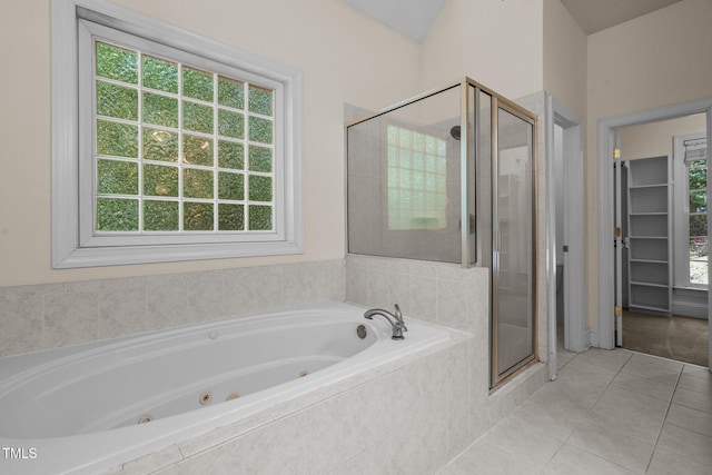 bathroom with a healthy amount of sunlight, a stall shower, a tub with jets, and tile patterned floors