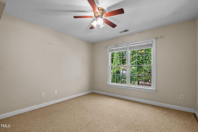 spare room featuring carpet, visible vents, and baseboards