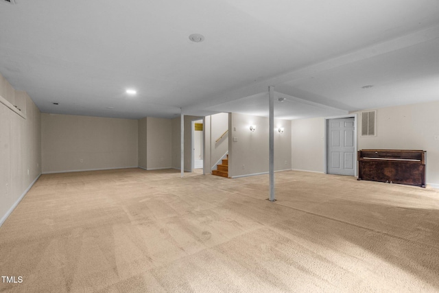 finished basement with light carpet, stairway, and visible vents