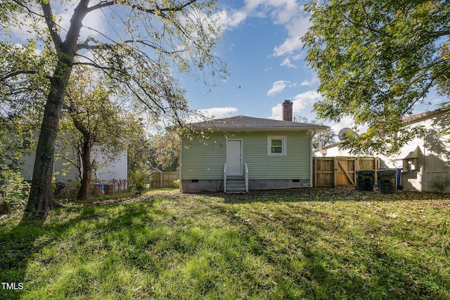 back of property featuring crawl space, a chimney, fence, and entry steps