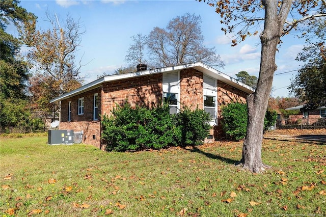 view of property exterior with crawl space, brick siding, and a lawn