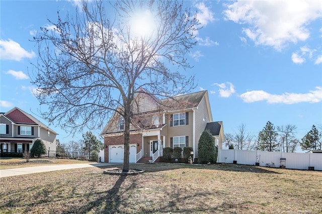 view of front facade featuring driveway, fence, and a front yard