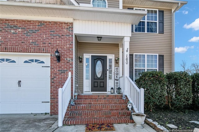 property entrance with an attached garage and brick siding