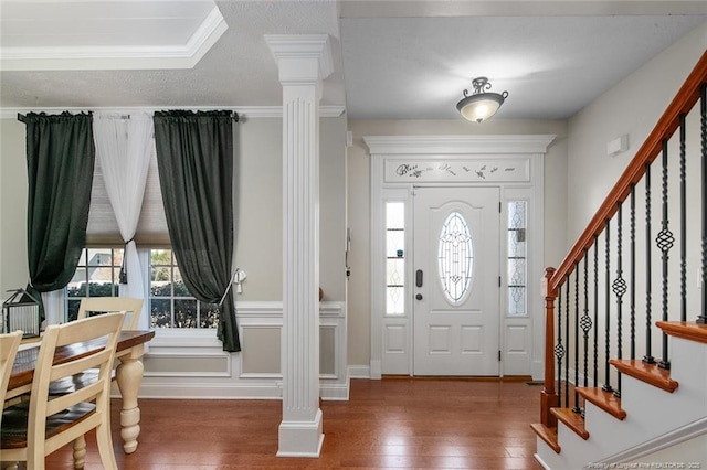 foyer with wood-type flooring, ornate columns, and stairs