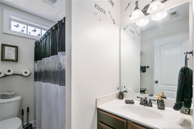 bathroom with a shower with shower curtain, visible vents, vanity, and toilet