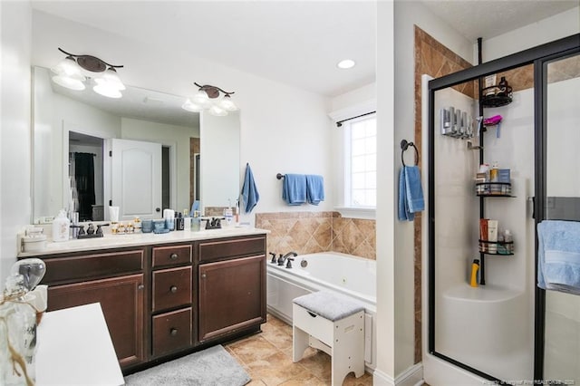 full bathroom with a jetted tub, a stall shower, double vanity, and a sink