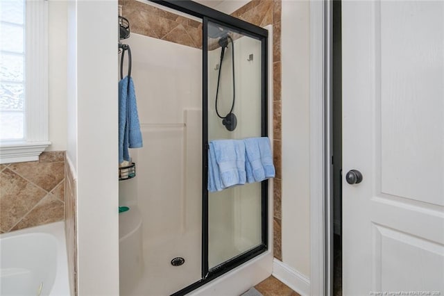 bathroom with a shower stall and a bath