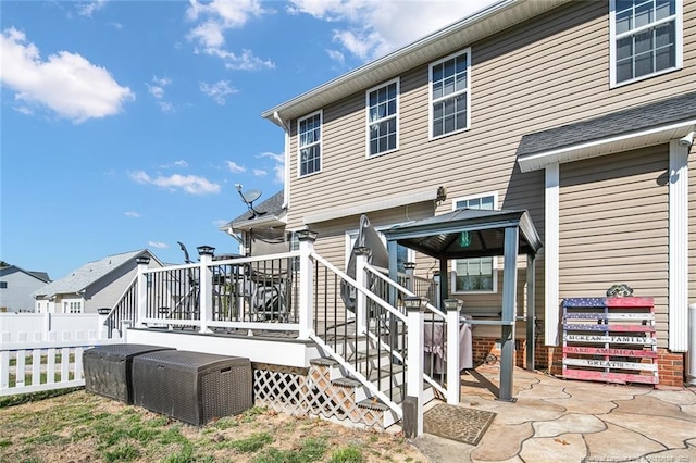 back of property with stairway, fence, and a wooden deck