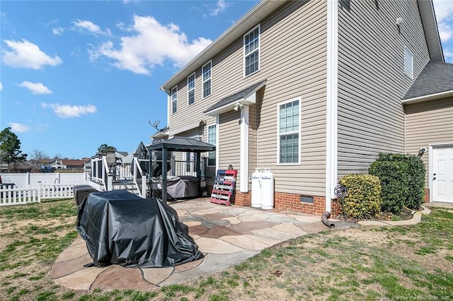 back of property with a gazebo, crawl space, a patio, and fence