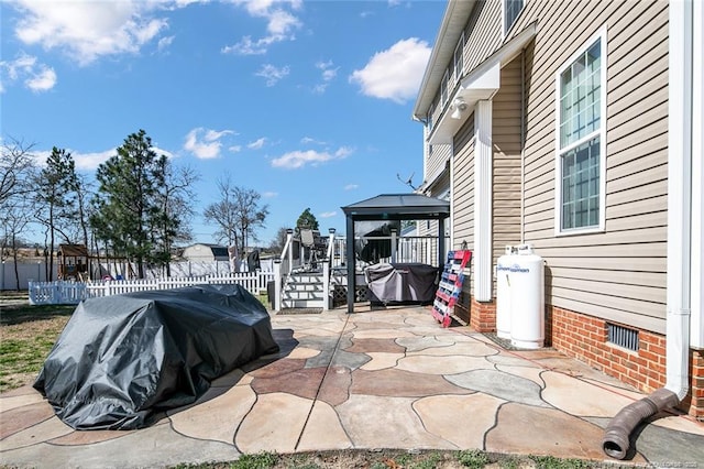 view of patio / terrace featuring a gazebo, grilling area, and fence