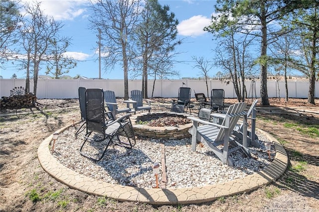 view of yard featuring a fenced backyard and a fire pit