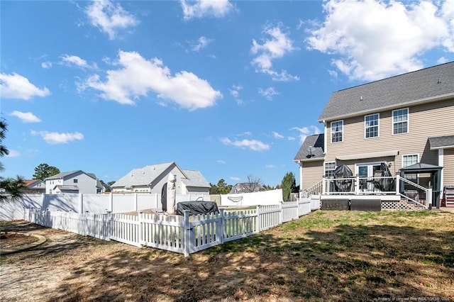 view of yard with a fenced backyard, a residential view, and a wooden deck