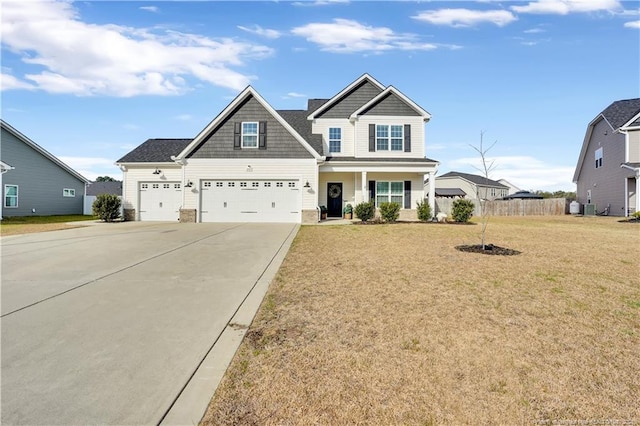 craftsman inspired home featuring a front yard, driveway, and fence