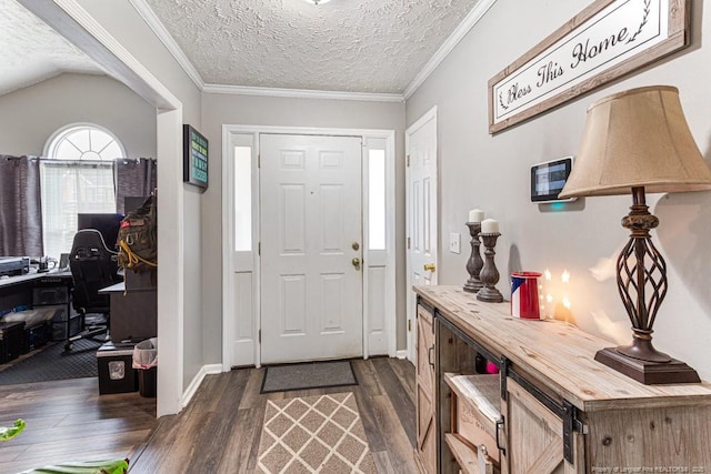 entrance foyer with ornamental molding, dark wood-type flooring, and a textured ceiling