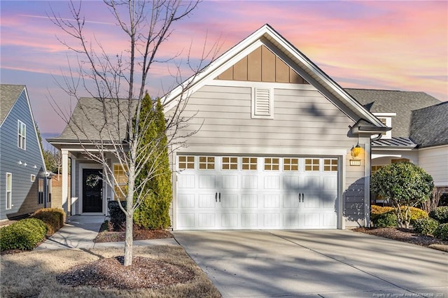 view of front of home featuring board and batten siding, driveway, and a garage