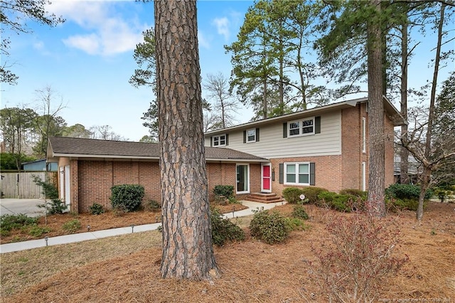 traditional-style house featuring fence and brick siding