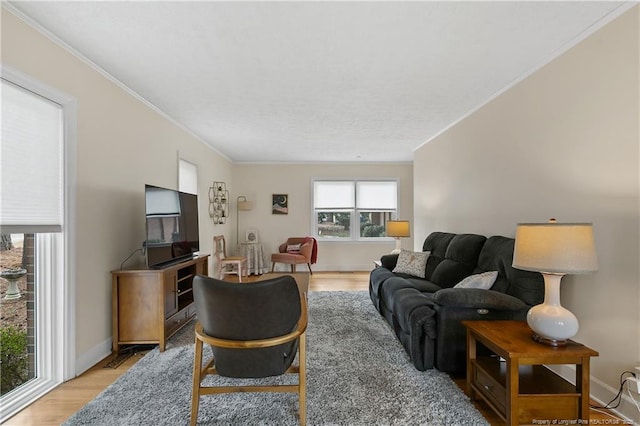 living room with baseboards, light wood finished floors, and crown molding