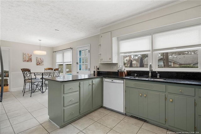 kitchen featuring light tile patterned floors, a peninsula, white dishwasher, and a sink