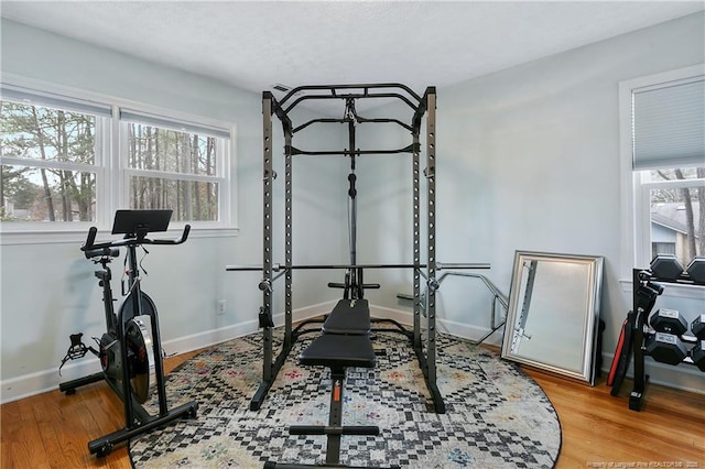 workout area featuring baseboards and wood finished floors