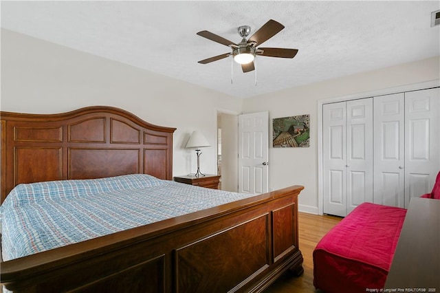 bedroom with a ceiling fan, a closet, visible vents, and light wood finished floors