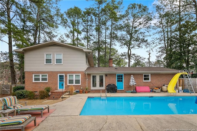 back of house with crawl space, fence, french doors, a patio area, and brick siding