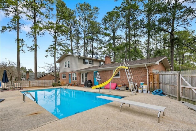 view of swimming pool featuring a diving board, a patio area, a fenced backyard, and a fenced in pool