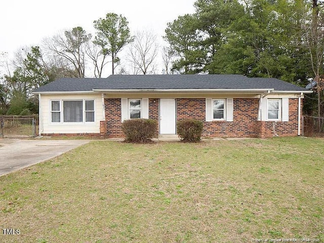 ranch-style house featuring brick siding, fence, a front lawn, and roof with shingles