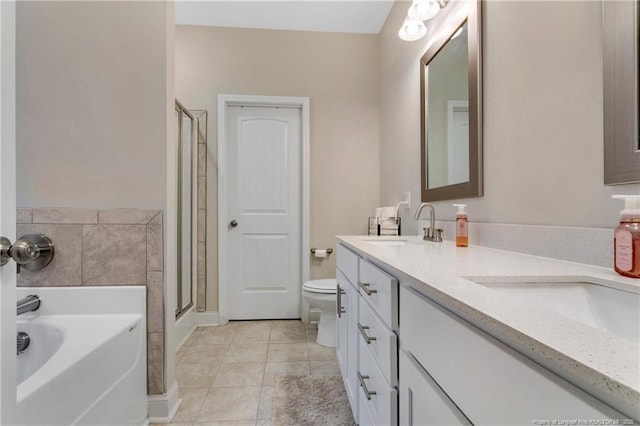 bathroom with double vanity, toilet, a garden tub, a shower stall, and a sink