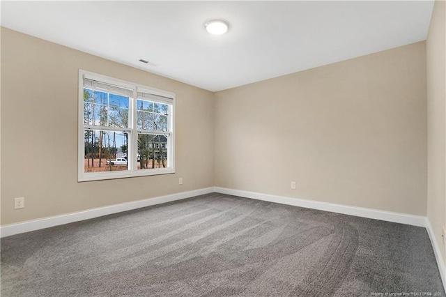 carpeted empty room with visible vents and baseboards