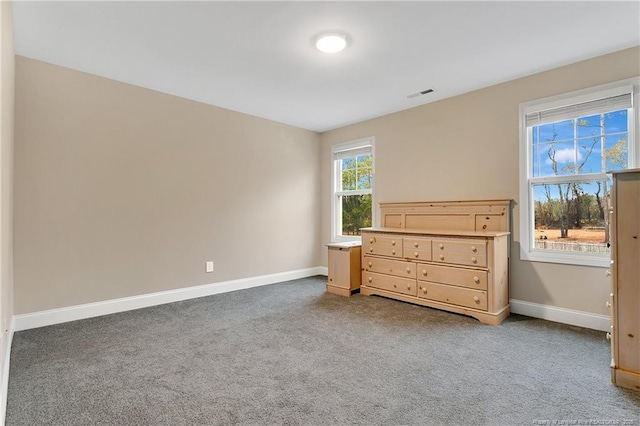 unfurnished bedroom with carpet, visible vents, and baseboards