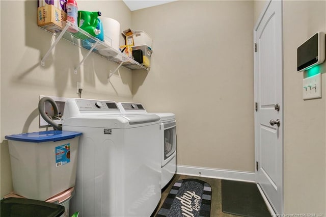 washroom with laundry area, baseboards, and washer and clothes dryer