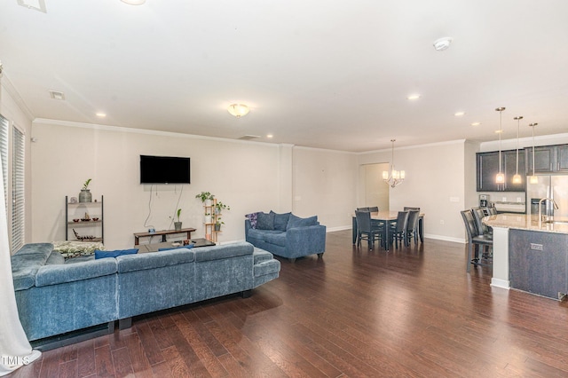 living room with dark wood-style floors, a notable chandelier, crown molding, and baseboards