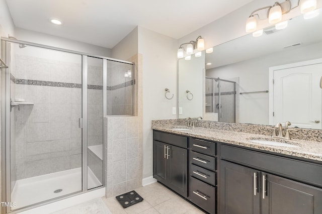 full bathroom with a sink, visible vents, a shower stall, tile patterned floors, and double vanity