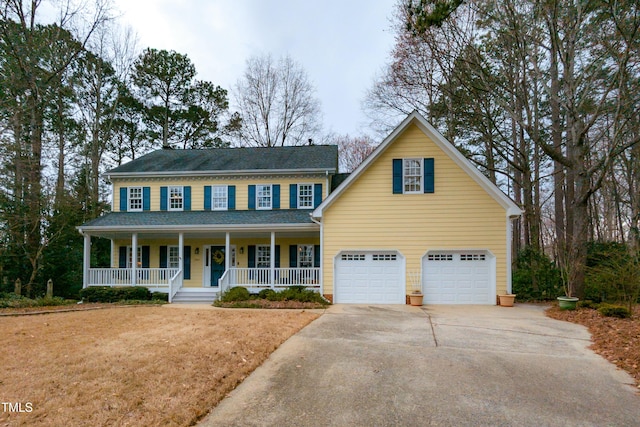 colonial home featuring a porch and concrete driveway