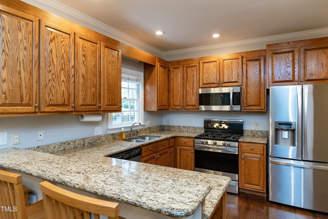 kitchen featuring a sink, a peninsula, brown cabinets, and stainless steel appliances