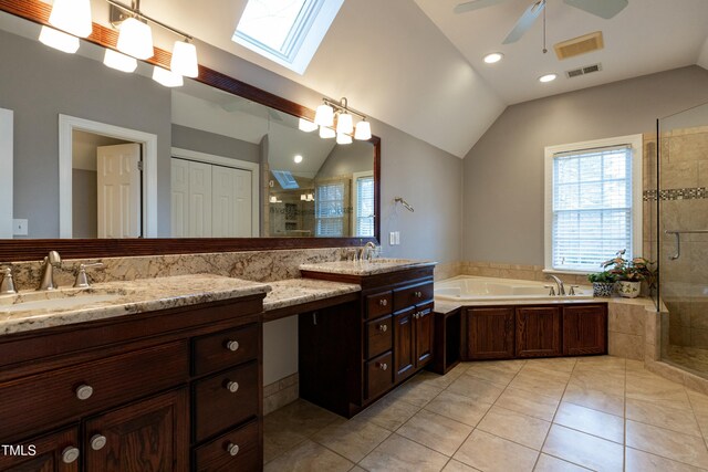 bathroom featuring vaulted ceiling with skylight, visible vents, a stall shower, and a sink