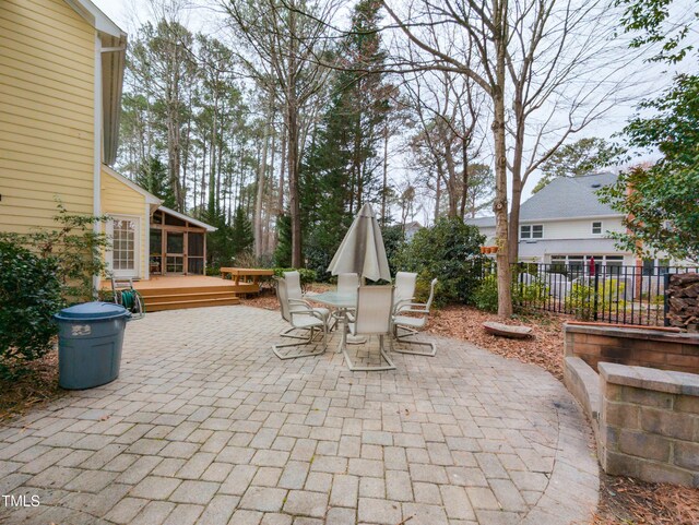 view of patio with outdoor dining area, a deck, and fence