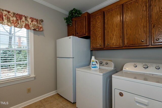 laundry area with crown molding, baseboards, washer and clothes dryer, light tile patterned floors, and cabinet space