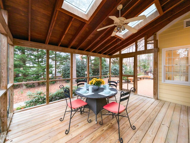 sunroom / solarium featuring lofted ceiling with skylight and ceiling fan