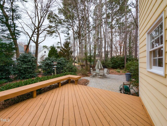 wooden deck featuring outdoor dining space and a patio