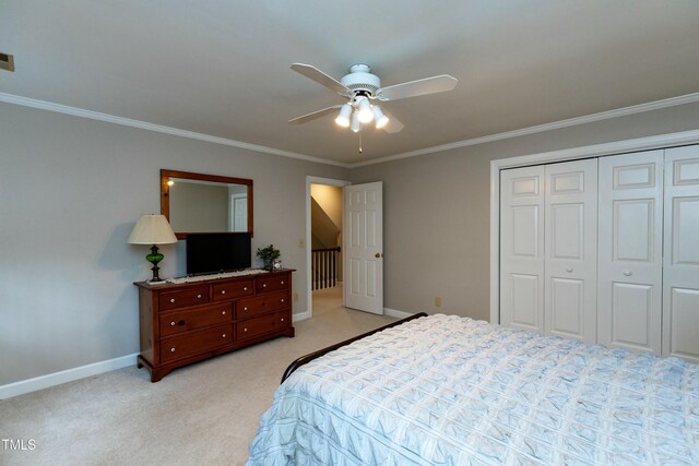 bedroom featuring crown molding, baseboards, a closet, and light carpet