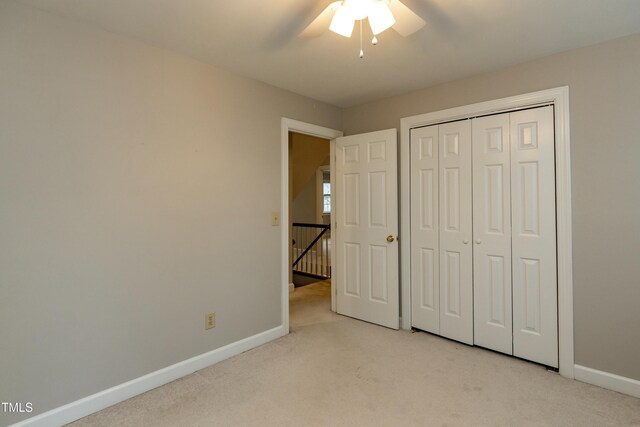 unfurnished bedroom featuring light colored carpet, baseboards, and ceiling fan