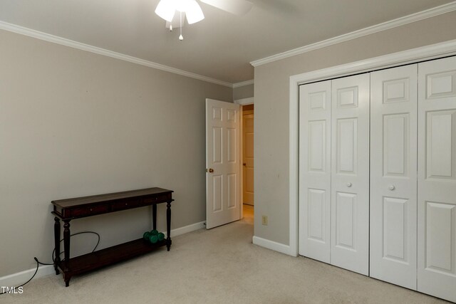 carpeted bedroom featuring ceiling fan, a closet, baseboards, and ornamental molding