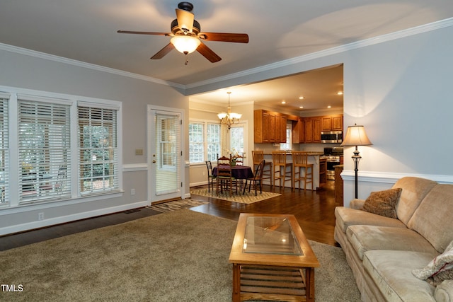 living room featuring baseboards, dark wood finished floors, crown molding, and ceiling fan with notable chandelier