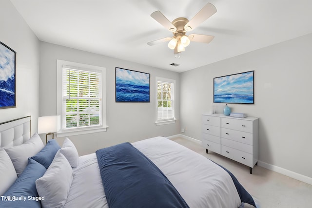 bedroom featuring baseboards, multiple windows, visible vents, and a ceiling fan