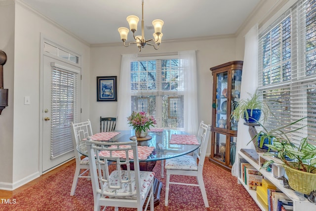 dining space with baseboards, an inviting chandelier, and crown molding